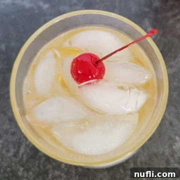 Fireball ginger ale cocktail with maraschino cherry garnish