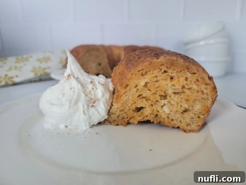 A perfectly plated slice of pumpkin angel food cake with a generous dollop of whipped cream, ready to be enjoyed as a delightful and light fall dessert.