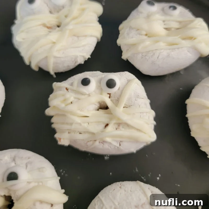 White chocolate mummy donuts on a black plate