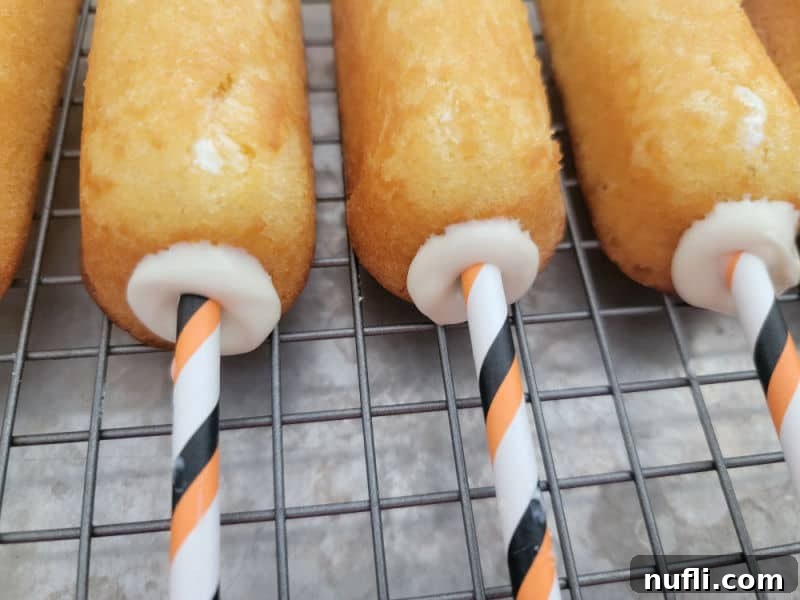 Orange striped straw in Twinkies, ready for the next step in making Halloween mummies