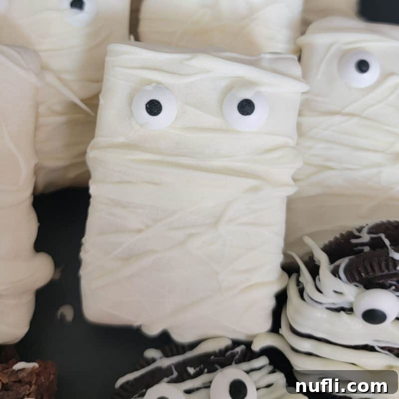 Monster Mummy Krispie Treats 2 Mummy Rice Krispie Treat on a dark platter, ready for Halloween festivities.