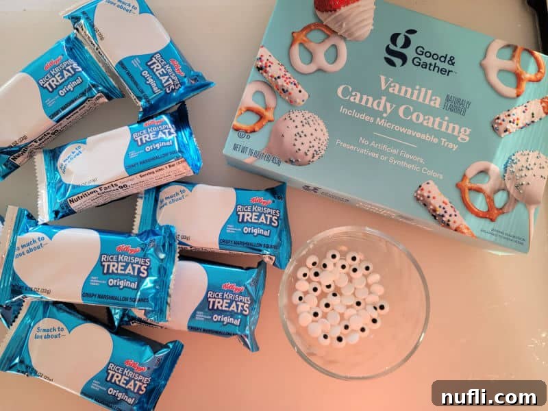 Monster Mummy Krispie Treats 3 Rice Krispie Treats, vanilla candy coating, and a bowl of candy eyes on a counter, ready for assembly.