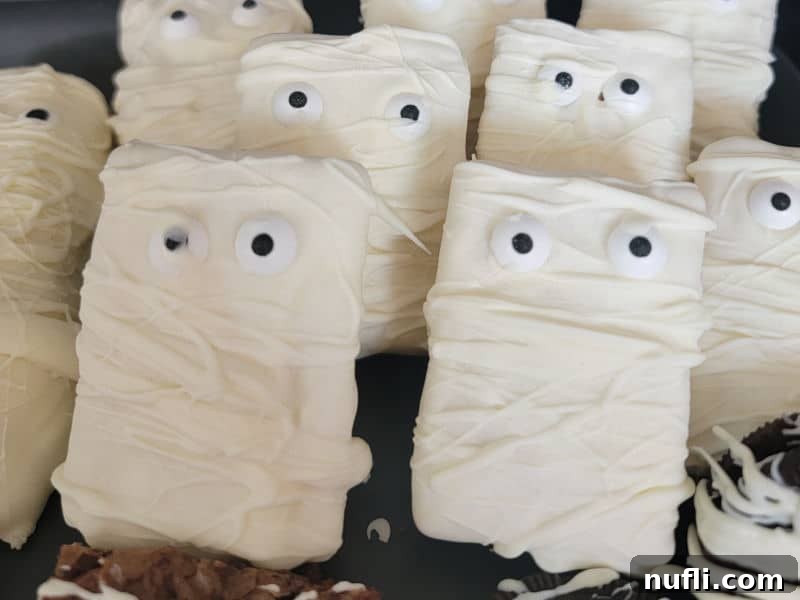 Monster Mummy Krispie Treats 6 Mummy Rice Krispie treats stacked together on a black platter, showcasing the finished product.