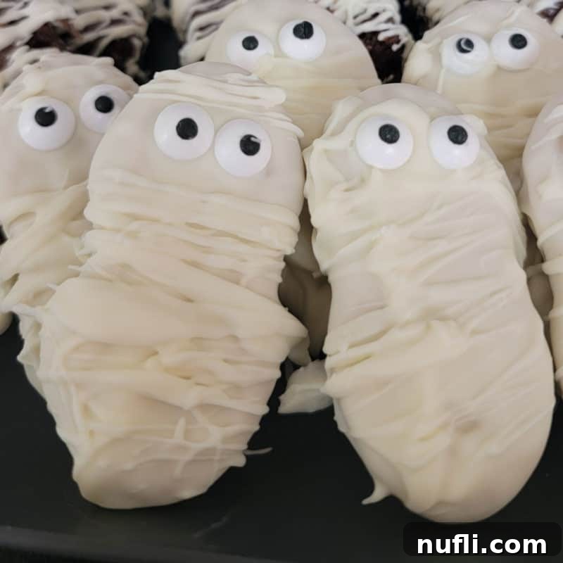 Nutter Butter Mummies arranged artfully on a dark platter, ready for a Halloween party