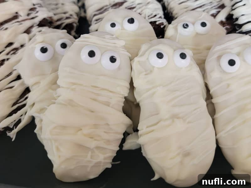 Nutter Butter Mummies playfully arranged on a black serving plate, ready for a Halloween celebration