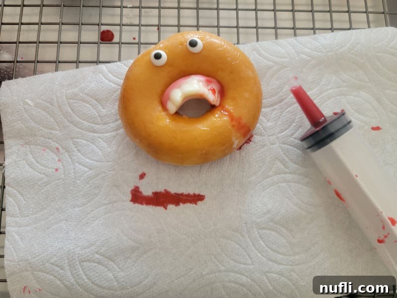 Realistic Edible Blood 4 Vampire donut with fangs dripping with edible blood next to a plastic syringe