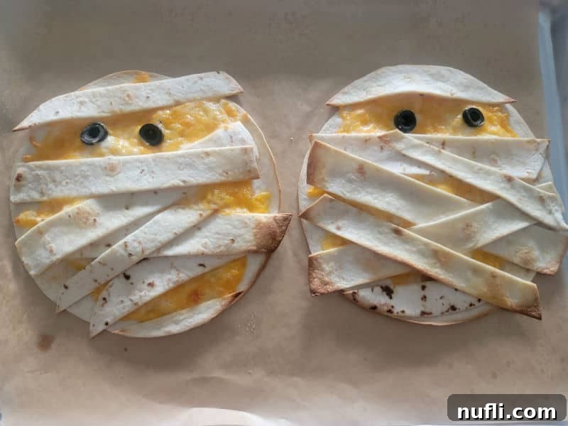 Two Mummy Quesadillas on parchment paper