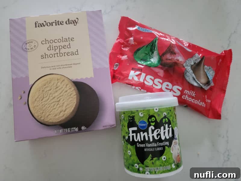 Witch hat cookies ingredients: chocolate dipped shortbread, Hershey Kisses, and green icing on a white background