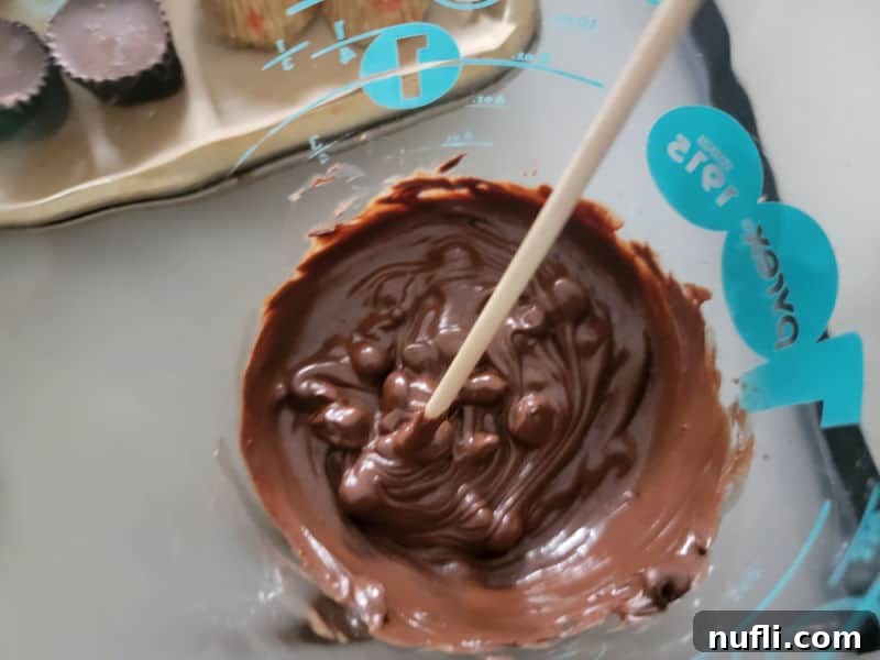 Melted chocolate chips in a small microwave-safe bowl, ready for assembling Reese's Bats.