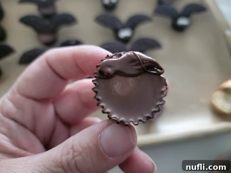 A mini Reese's Peanut Butter Cup with a dab of melted chocolate on top, ready for Oreo wings.