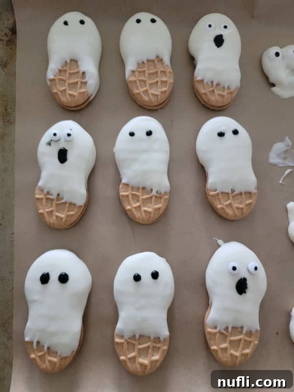 Nutter Butter Ghosts on parchment paper with different faces