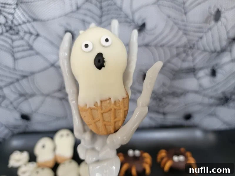 Nutter butter ghost held by a skeleton hand