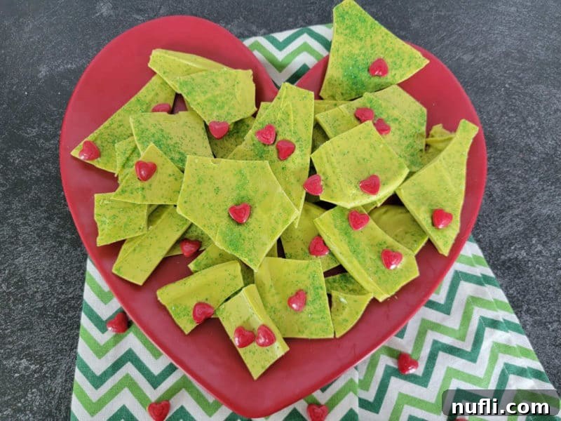 Festive Grinch Bark Made Easy 9 Homemade Grinch Bark on a red plate with a green napkin