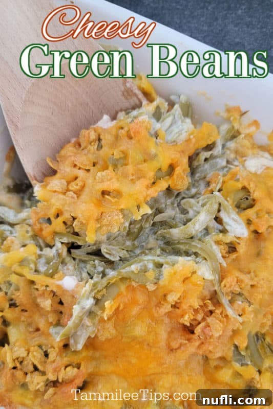 Deliciously creamy cheesy green beans in a serving dish with a wooden spoon, ready to be enjoyed as a holiday side.