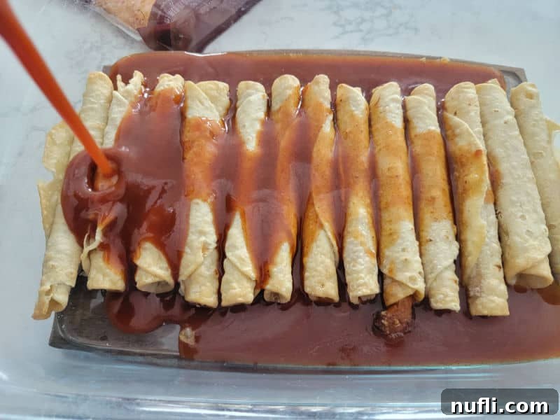 Enchilada Sauce pouring over frozen enchiladas to make taquito enchiladas