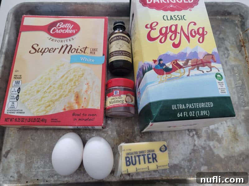 Eggnog Cookie ingredients white cake mix, vanilla, ground nutmeg, eggnog, eggs, butter on a silver baking sheet
