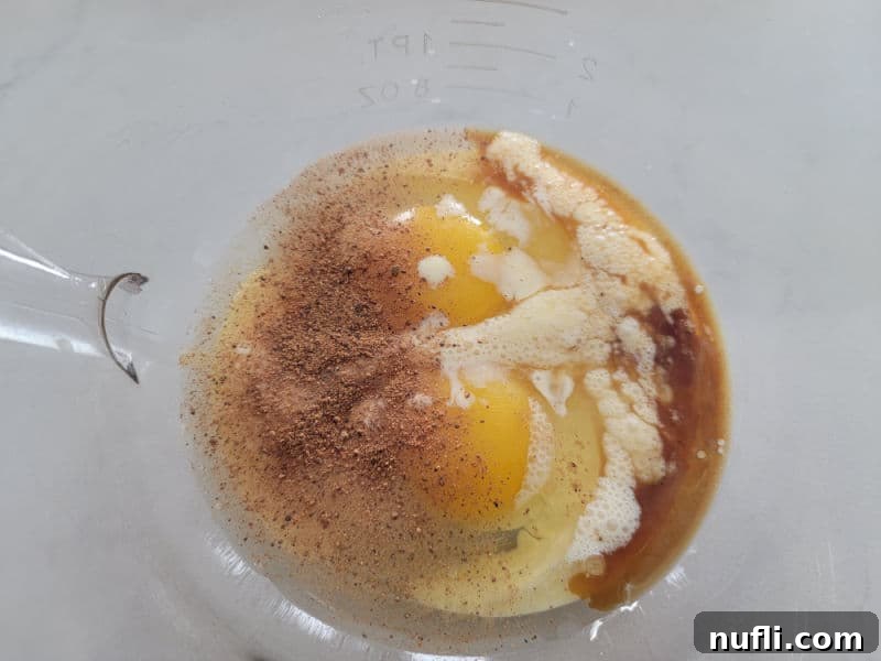 Wet ingredients in a glass bowl for eggnog cake mix cookies