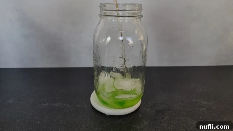 Amaretto pouring into a cocktail shaker to make a Broken Down Golf Cart Drink