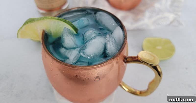 Blue Moscow Mule in a copper mug with a lime wedge