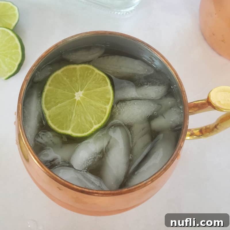 Mastering Ginger Beer Mixology 8 Mexican Mule with a lime circle in a copper mule mug next to more lime circles