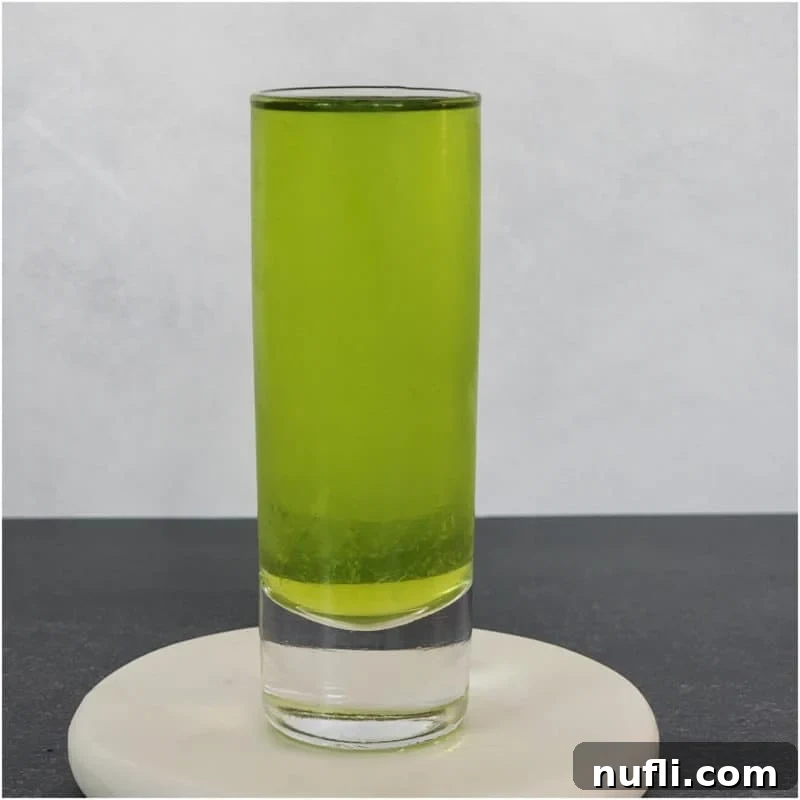 Midori Mixology: Your Ultimate Guide 7 A bright green Broken Down Golf Cart shot, served in a small glass and placed on a coaster.