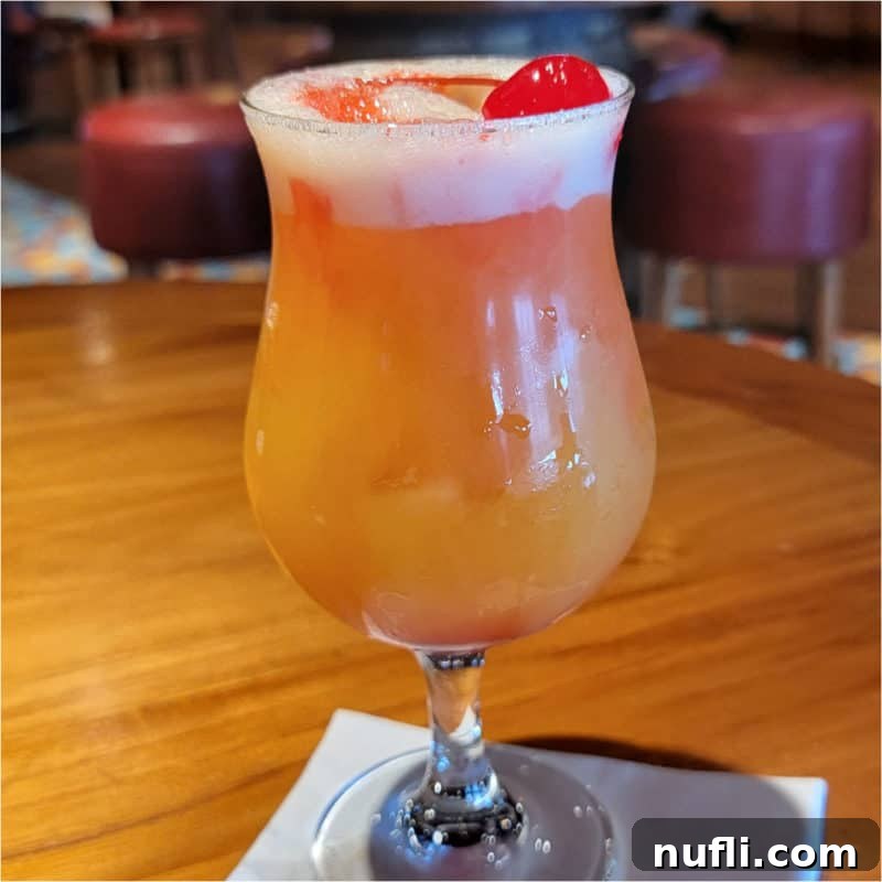 Rump Jumper cocktail in a hurricane glass garnished with a cherry