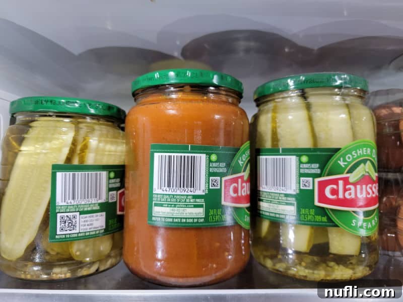 The Two Ingredient TikTok Taco Pickle Sensation 6 taco pickles in a jar in the refrigerator with other dill pickles