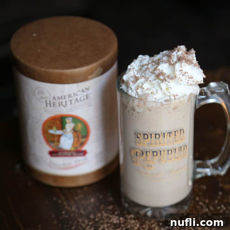 Boozy Hot Chocolate garnished with whipped cream in a glass mug next to American Heritage chocolate