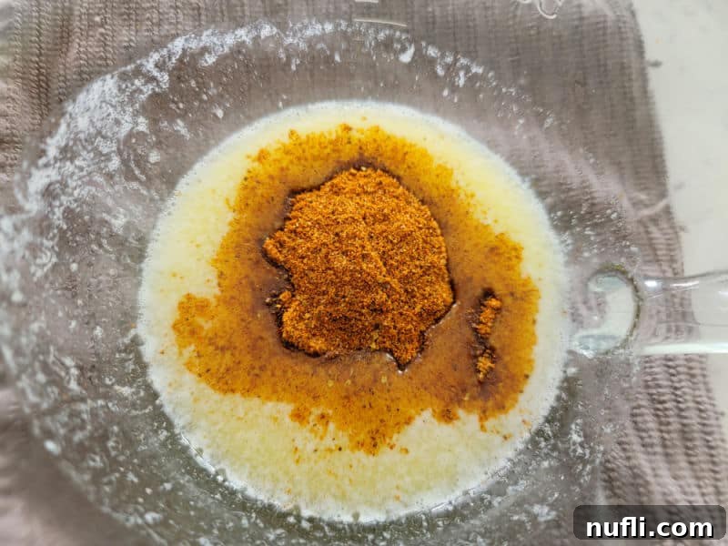 Old Bay seasoning in melted butter in a glass bowl