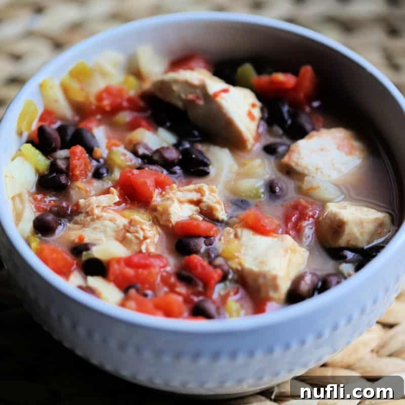 Hearty Spicy Chicken Chili in a white bowl, ready to be enjoyed.