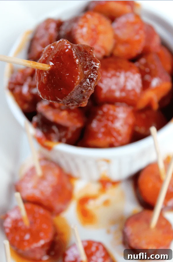 Spicy barbecue kielbasa in a bowl with one piece on a toothpick