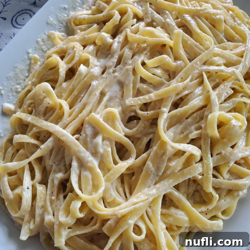 Olive Garden's Best, Made Easy at Home 5 A white platter showcasing creamy Olive Garden Fettuccine Alfredo sauce