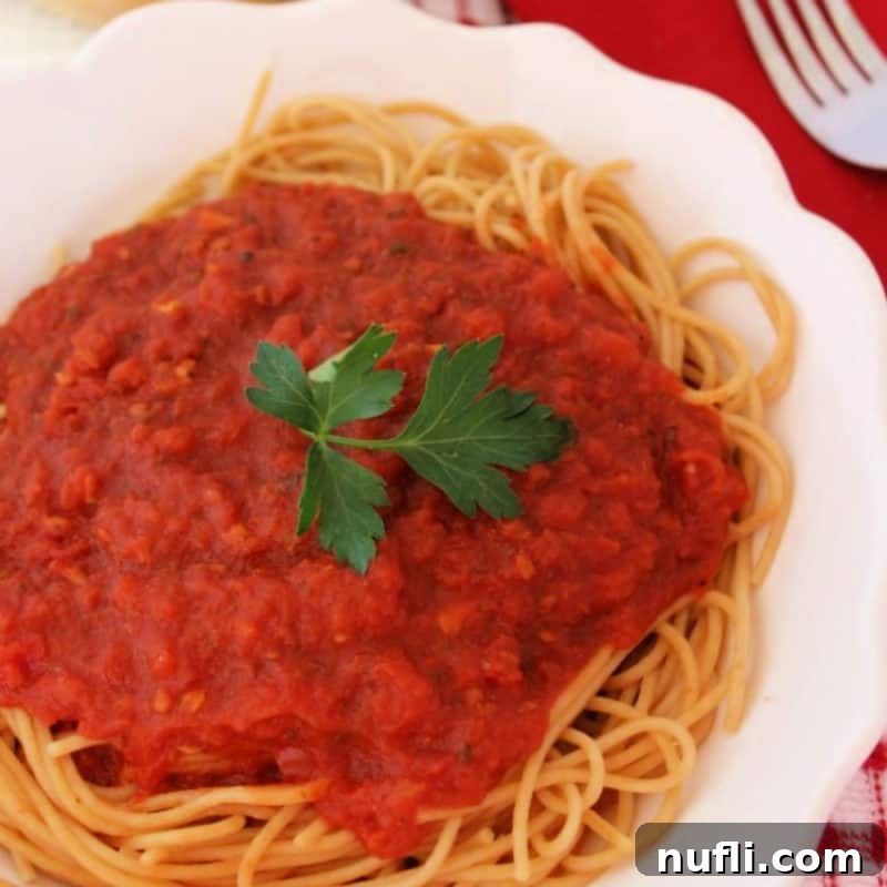 Olive Garden's Best, Made Easy at Home 6 Spaghetti tossed with vibrant Olive Garden Marinara sauce on a white plate