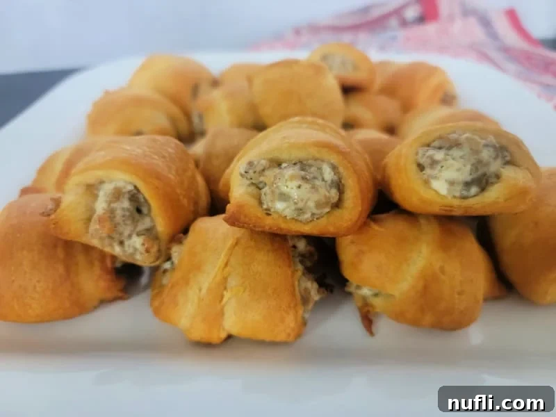 Stack of sausage cream cheese crescent rolls on a white platter