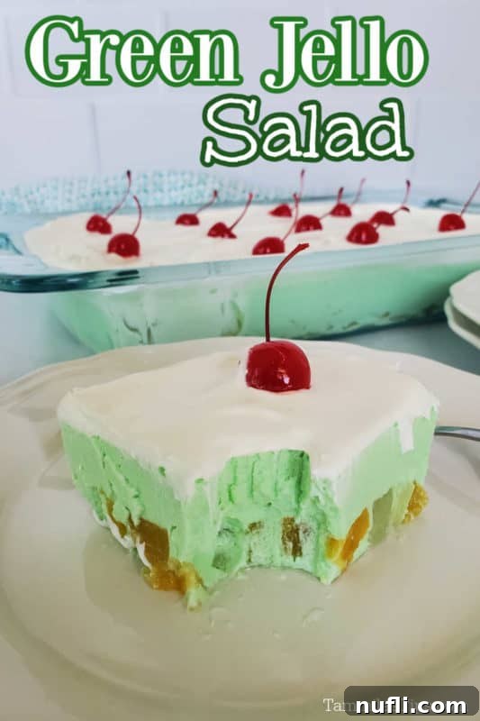Green Jello Salad text over a slice of green jello salad with a maraschino cherry