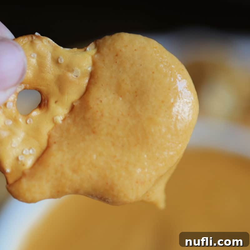 Score Big with These Game Day Appetizers 15 Bagel chip covered in Guinness Beer Cheese Dip above a bowl