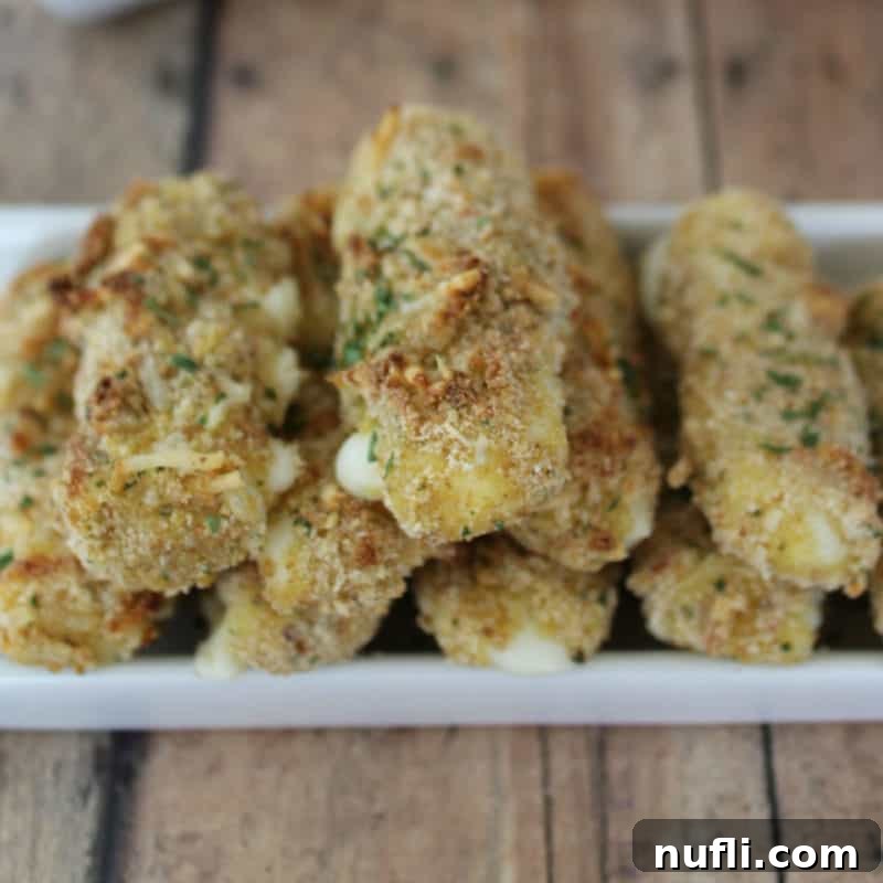 Score Big with These Game Day Appetizers 37 Homemade Baked Mozzarella Sticks on a white platter