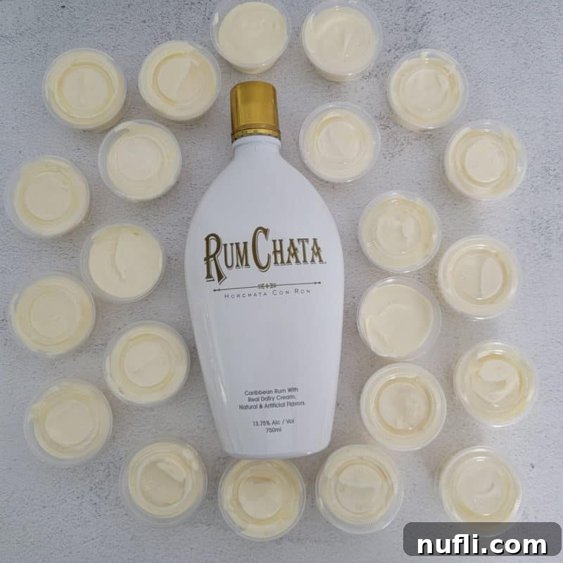 A delightful arrangement of RumChata Pudding Shots, artfully spread around a bottle of RumChata, inviting indulgence.