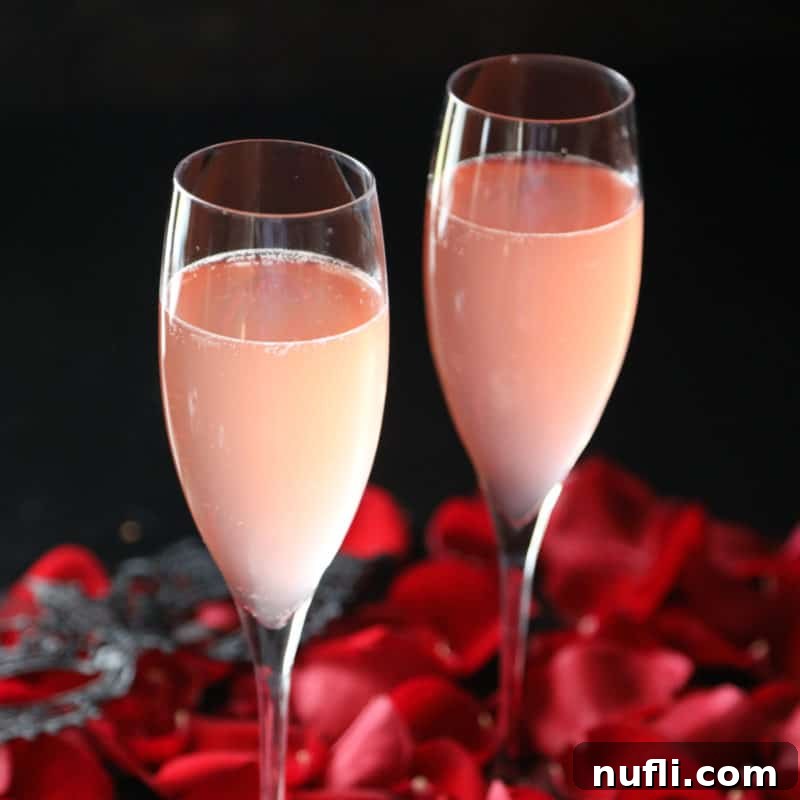Elegant Kinky Bubbles cocktails presented in champagne glasses, surrounded by scattered rose petals, evoking a celebratory mood.