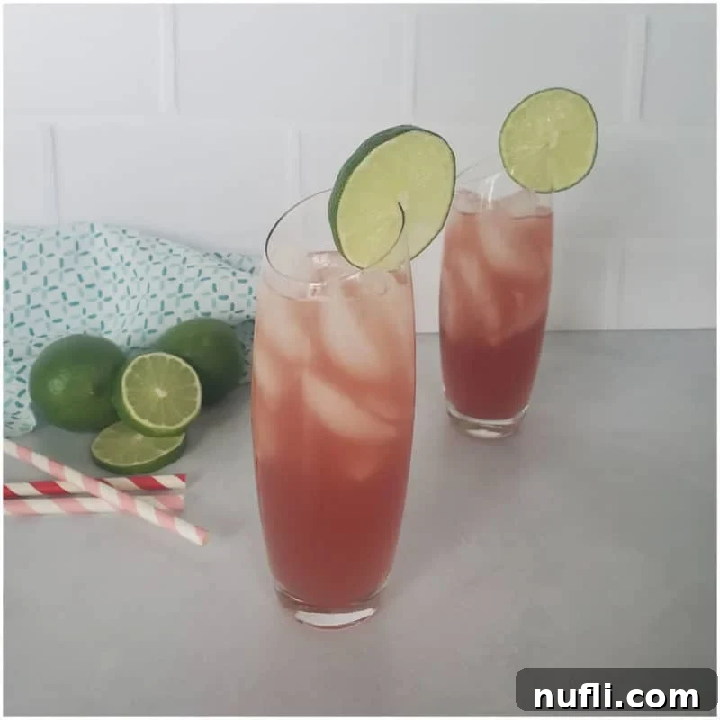 Amazing Cranberry Cocktails Made Easy 5 Two Bay Breeze Cocktails with lime circles next to a few fresh limes, capturing a tropical, refreshing vibe.