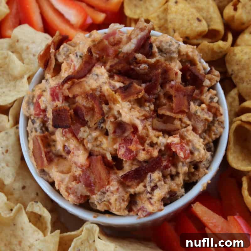 Deconstructed Bacon Cheeseburger Dip, surrounded by fresh pepper strips and crispy tortilla chips, perfect for dipping