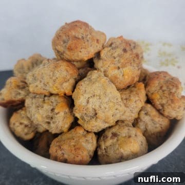 White bowl filled with Cheddar Bay Sausage Balls next to a cloth napkin
