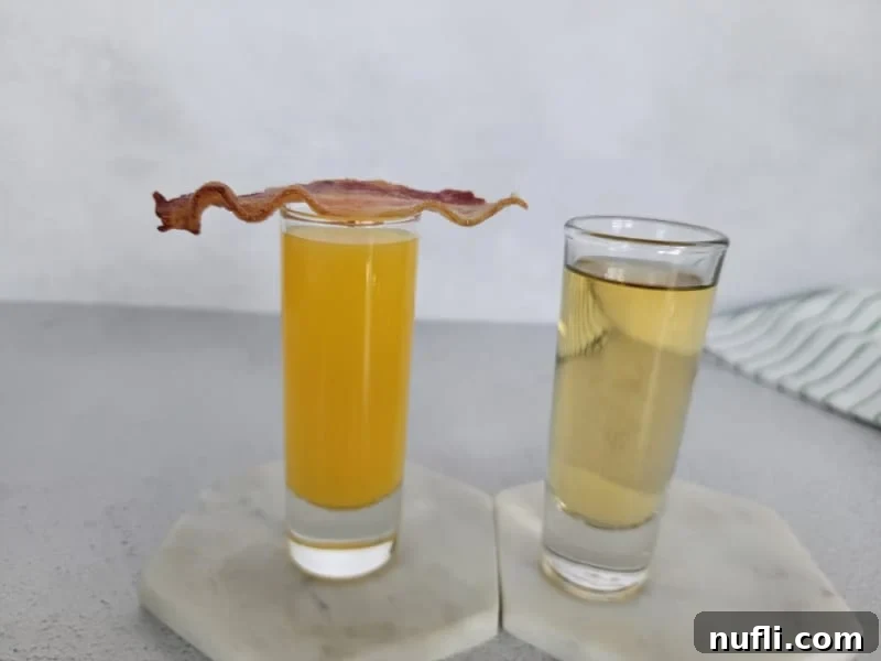 Irish Breakfast shot with bacon on top of orange juice next to a filled shot glass