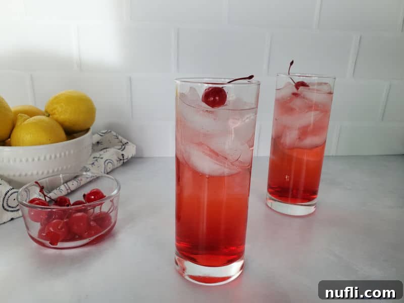 Dirty Shirley Cocktail next to a bowl of cherries and lemons