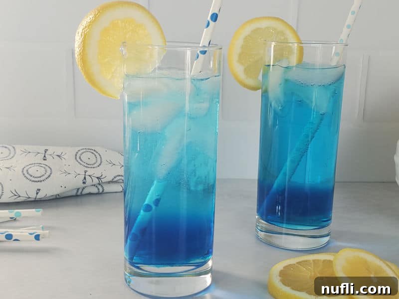 2 bright blue cocktails in tall glasses with lemon wheels, sex in the driveway cocktails