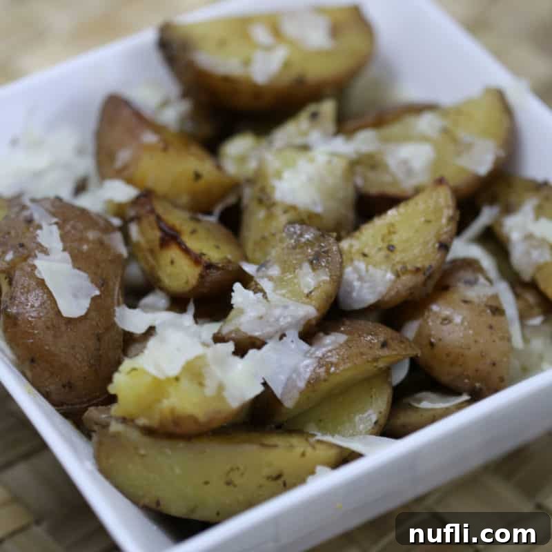 Perfectly roasted Parmesan Potatoes, generously seasoned and served in a classic white bowl.