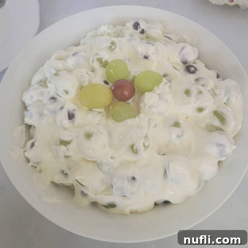 A vibrant Grape Salad featuring both green and red grapes, elegantly served in a pristine white bowl.