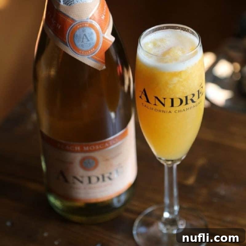 A frosty, sweet peach moscato cocktail elegantly presented in a champagne flute, placed next to a bottle of moscato, highlighting its key ingredient.