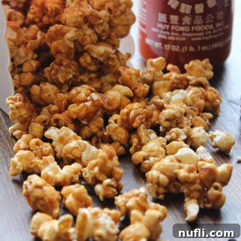Sriracha caramel popcorn spread out from a popcorn container 