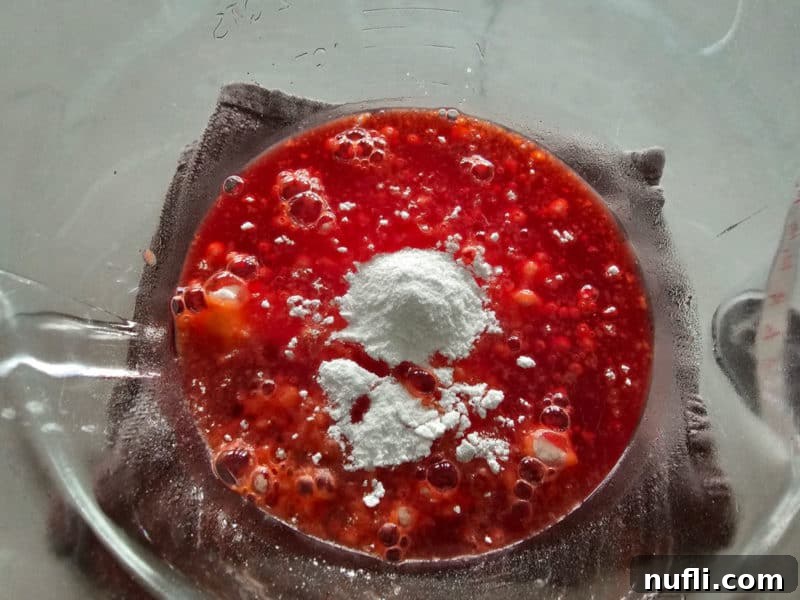 Strawberry Cloud Delight 5 strawberry jello with vanilla pudding mix on top in a glass bowl